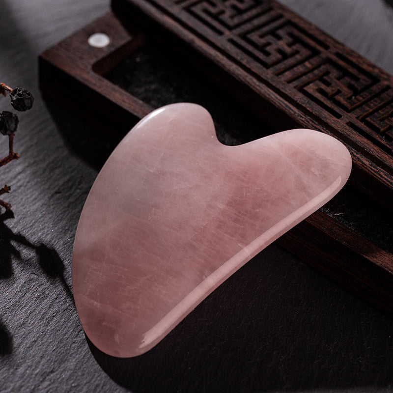 Rose quartz gua sha set displayed with acupoint guide